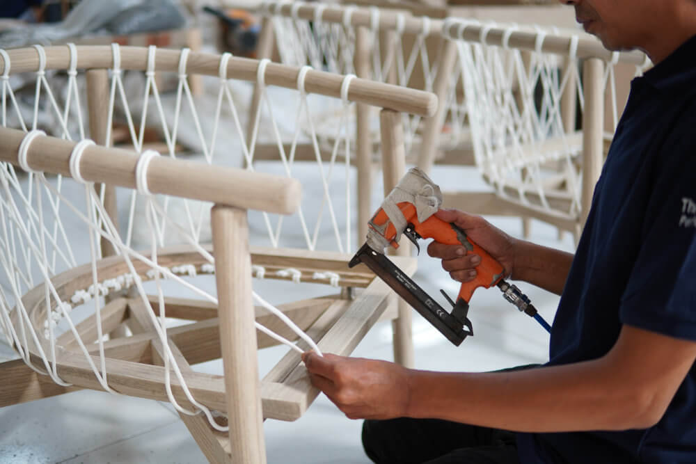 a worker weaving furniture at factory
