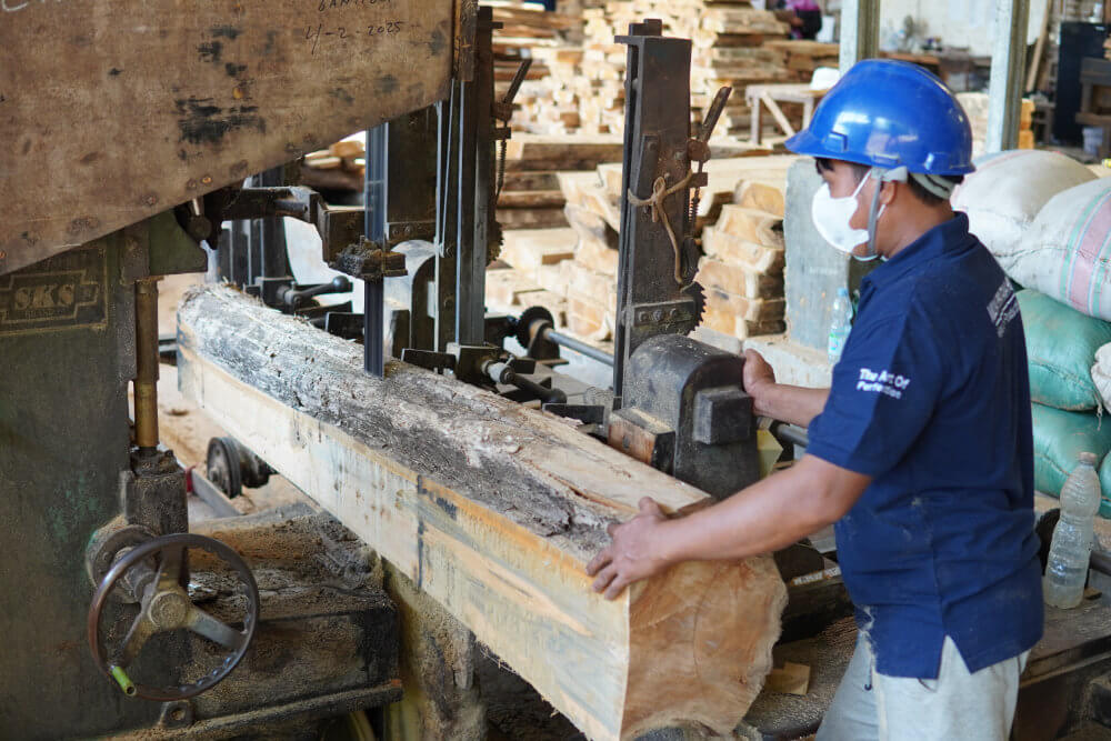 Workers cutting wood log into wood plank at Indonesian Furniture Factory