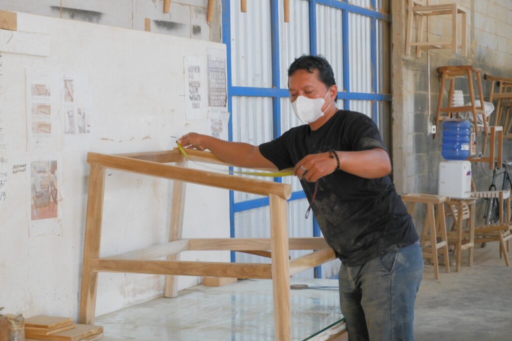 Indonesian furniture manufacturer QC staff measuring wooden frame dimensions for accuracy during in-house production at MPP Furniture