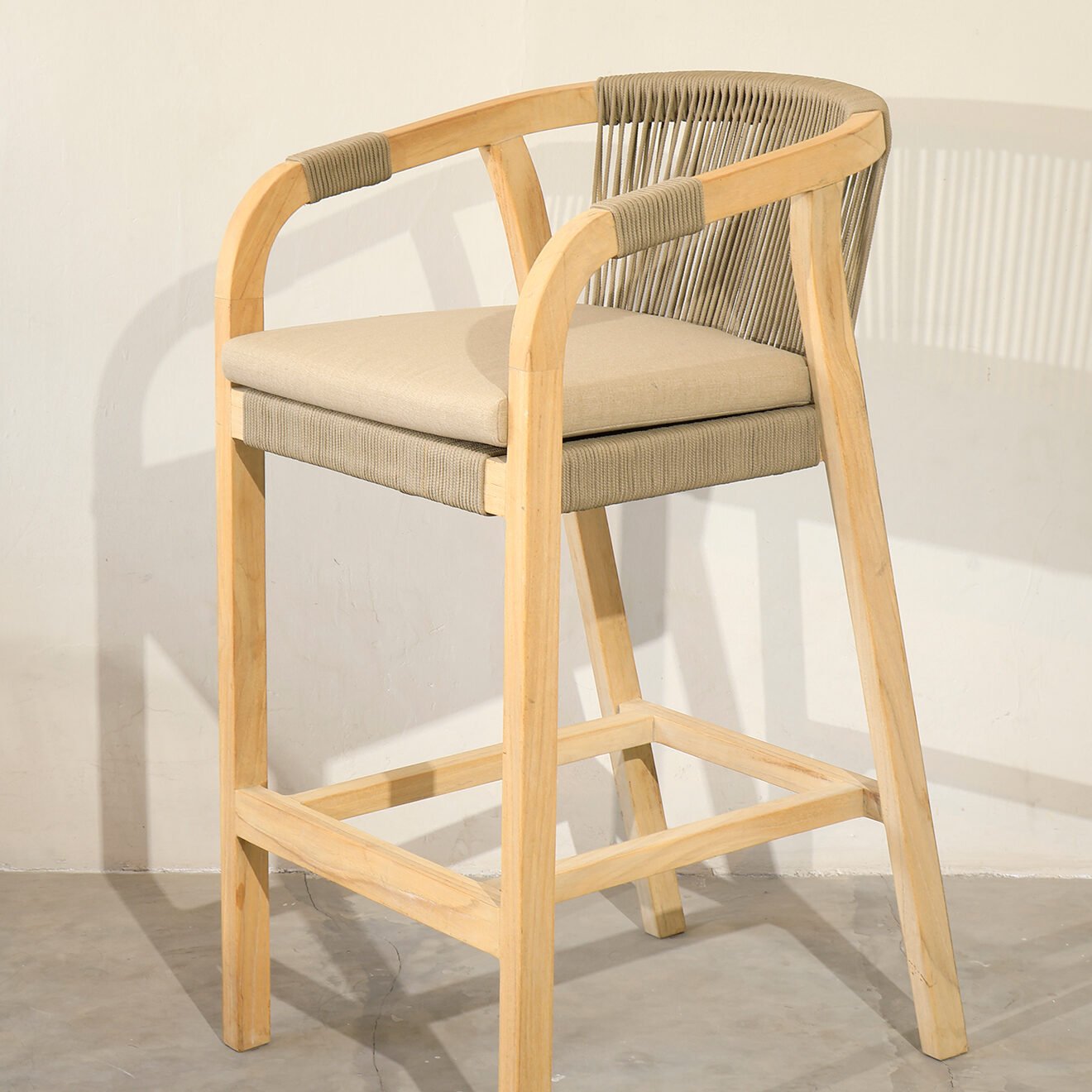 Rimini Outdoor Counter Stool made from Indonesian teak wood with beige outdoor rope and cushion seat, ideal for outdoor bar or kitchen island settings.