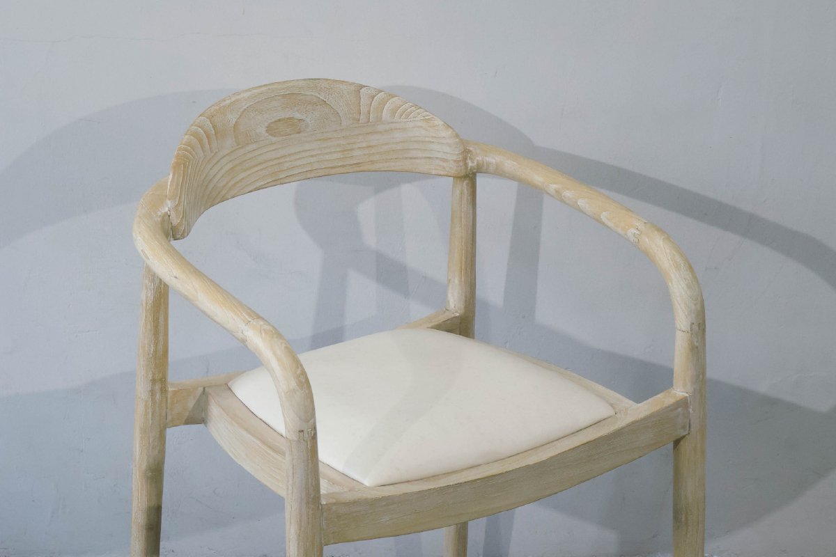 Custom upholstered dining chair, the Crescent model, shown in a light whitewashed Mindi wood finish with a cream fabric cushion for a coastal look. Made by Custom Furniture Manufacturer MPP Furniture