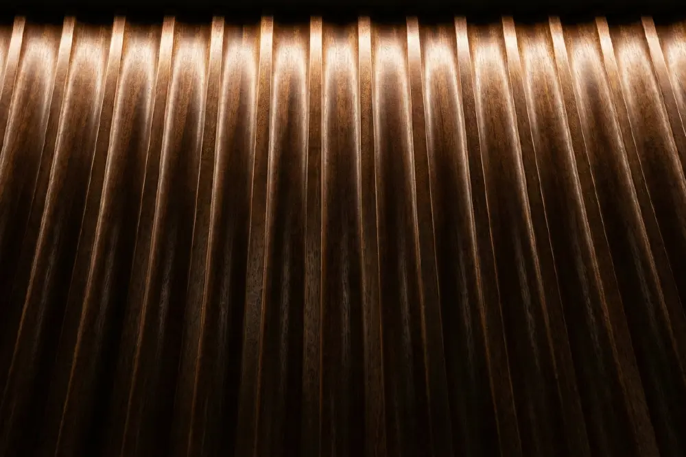 Architectural detail of Mahogany Interior Design using modern fluted (tambour) wood paneling with dramatic angled lighting