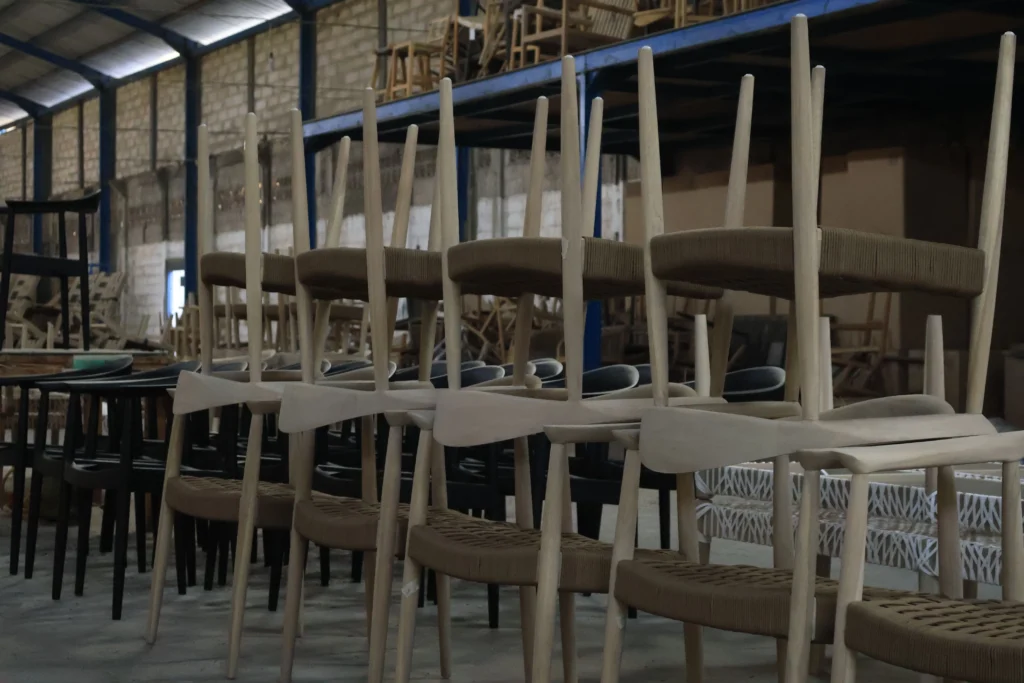 managing furniture inventory (2) Stacks of unfinished wooden chairs in a manufacturing warehouse highlighting the space requirements for managing furniture inventory effectively