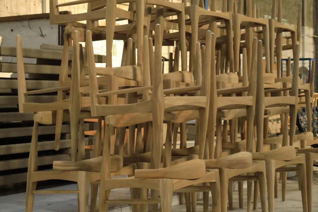 moq for furniture retailers (2) High stacks of unfinished wooden chair frames illustrating the warehouse space and volume required when managing MOQ for furniture retailers.