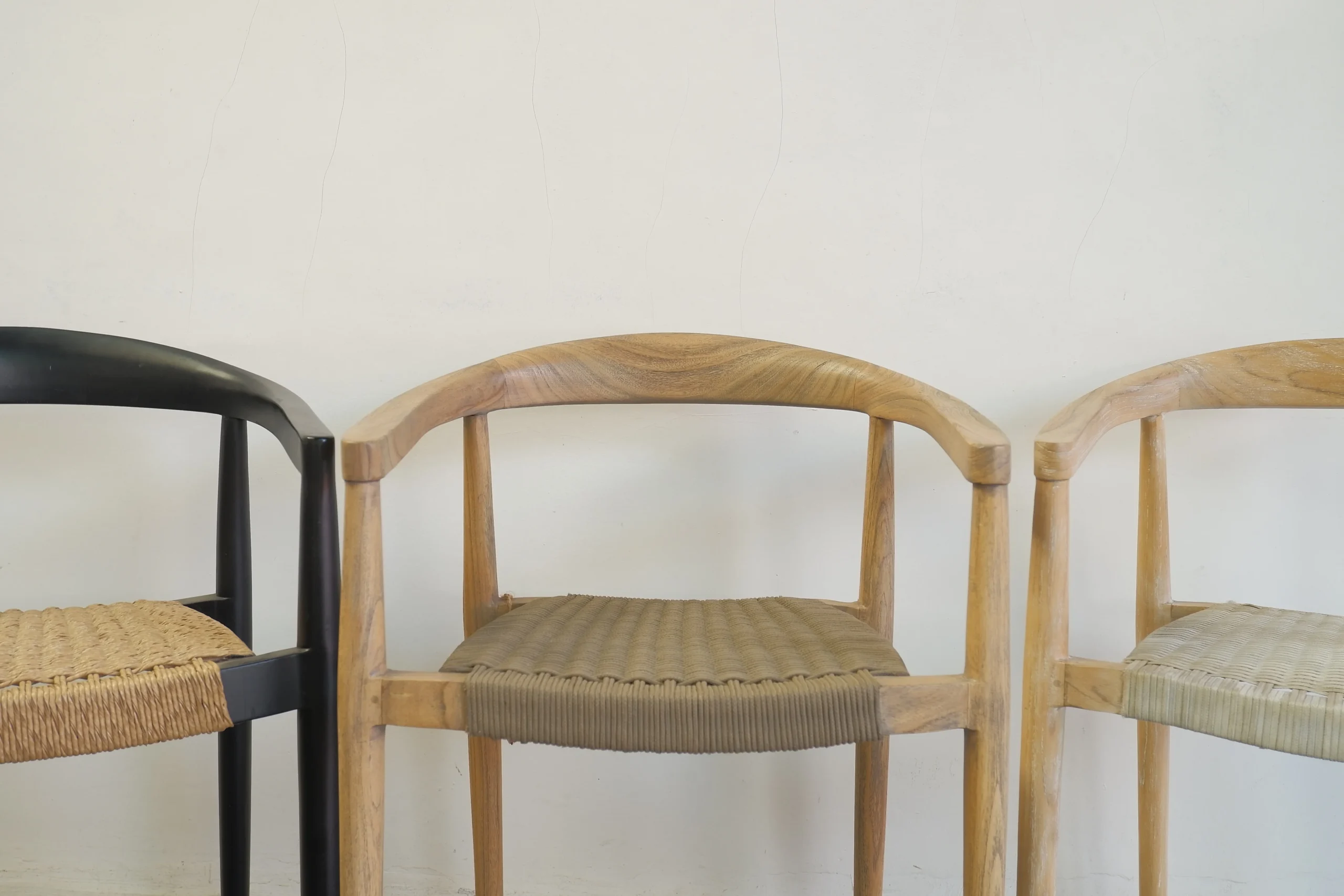 Three finished wooden chairs with varied colors showing quality standards that impact retail furniture pricing.