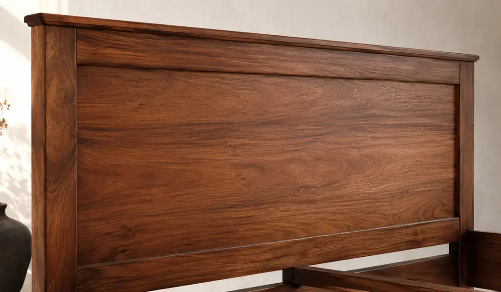 Close-up of an Indonesian mahogany headboard showing natural wood grain, warm finish tone, and refined edge detailing.