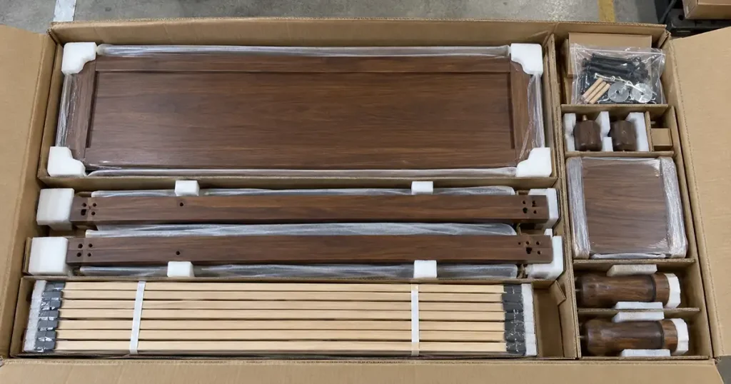 Protected bedroom furniture components arranged inside an export carton