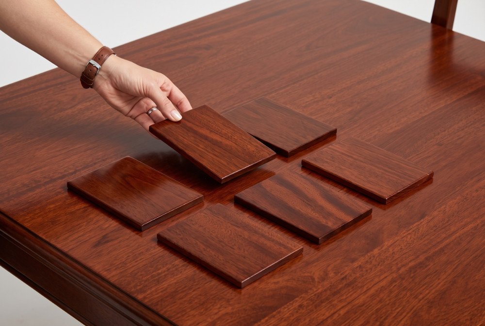 Matched mahogany wood finish samples placed on a finished dining table